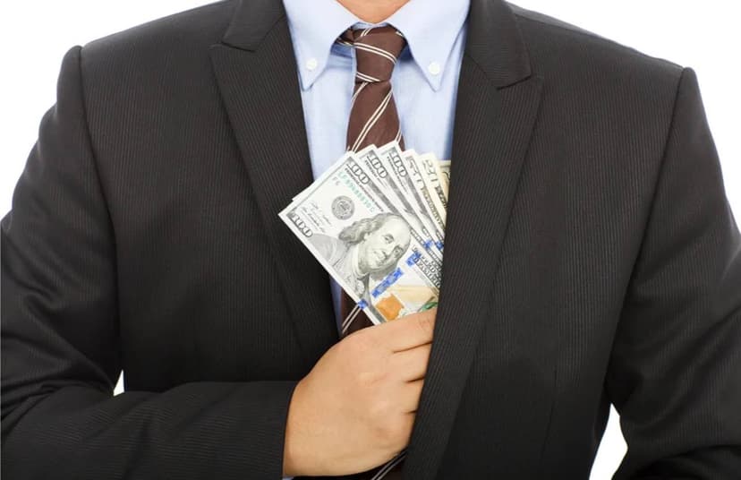 Человек в деловом костюме с деньгами в нагрудном кармане