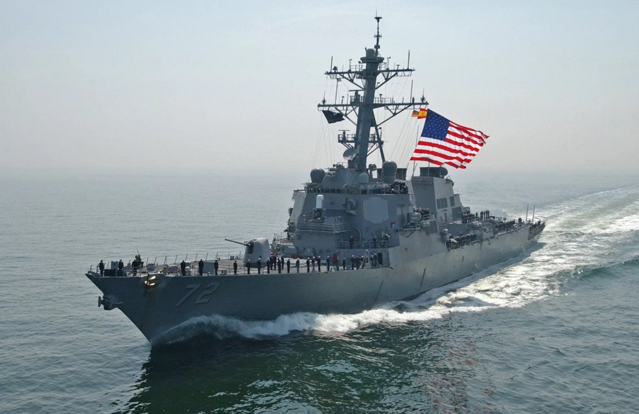 Американское военное судно на фоне океана с развевающимся флагом США